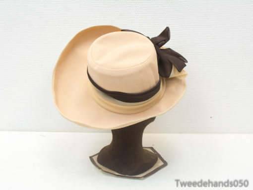 Elegant beige wide-brimmed hat with a black bow, ideal for summer fashion and outdoor events.