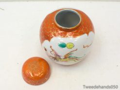 Vibrant ceramic jar with dragon motifs and orange lid, adding artistic flair to your decor.