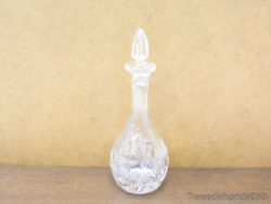 Elegant crystal decanter with floral designs, ideal for upscale beverage service and decor.