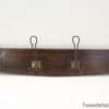 Rustic dark wood coat rack with vintage brass hooks, perfect for stylish entryway organization.