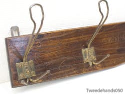 Rustic wooden coat rack with antique brass hooks, perfect for stylish entryway organization.