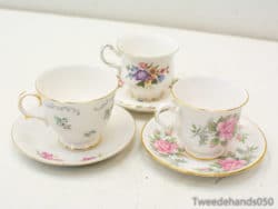 Delicate porcelain teacups with floral designs and gold accents, perfect for elegant tea gatherings.