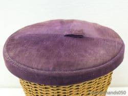 Charming wicker basket with a luxurious purple lid for stylish home decor and storage.