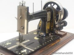 Vintage black sewing machine with gold detailing, showcasing craftsmanship and nostalgic elegance.