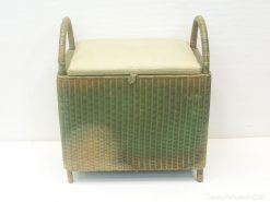 Stylish rattan storage box with cushion and handles for extra seating and organization.