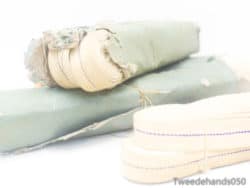 Vintage green and cream fabric rolls, ideal for crafts and home decor projects.