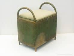 Charming vintage wicker ottoman with plush cushion and elegant handles for stylish storage solutions.