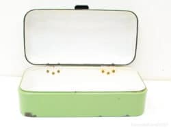 Vintage green metal box with white interior and brass details for stylish storage solutions.