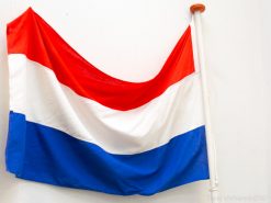 Vintage Dutch flag in vibrant red, white, and blue, symbolizing national pride and heritage.