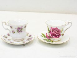 Elegant porcelain teacups with floral designs, gold rims, ideal for tea gatherings or decor.