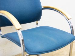 Sleek blue chair with chrome frame and wood armrests, perfect for modern interiors.