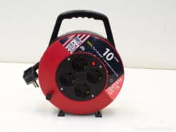 Red extension reel with 10m cable and four outlets for home and outdoor use.