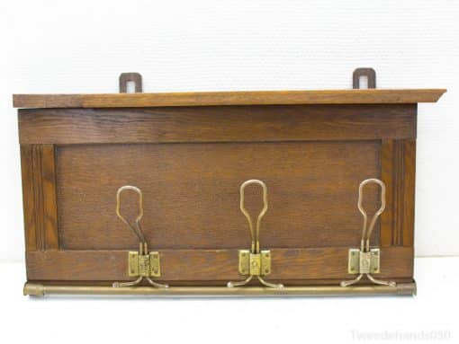 Elegant dark wood coat rack with brass hooks, perfect for vintage-inspired entryway organization.