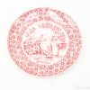 Red decorative plate featuring tranquil birds and floral designs, perfect for collectors and decor.