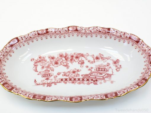 Elegant oval porcelain platter with rich red floral motifs and luxurious gold trim.