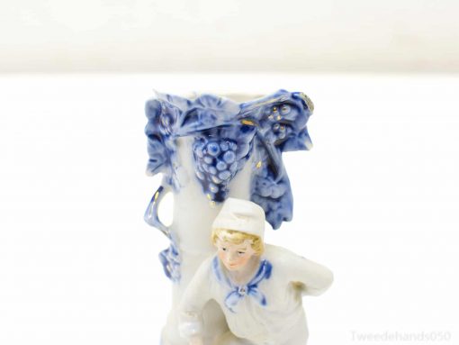 Beautiful porcelain vase featuring a young boy and intricate blue and white grapevine details.