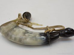 Antique horn with leather strap, featuring stunning craftsmanship and cultural significance.