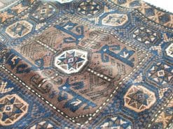 Elegant geometric rug in deep blues and browns, showcasing traditional craftsmanship and warmth.