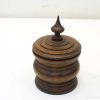 Elegant wooden storage container with a decorative tapered lid and finial for stylish decor.