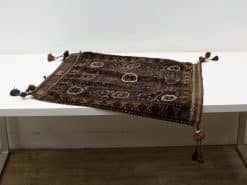 Elegant handmade rug with intricate patterns and vibrant tassels in rich earth tones.