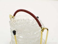 Elegant glass coaster holder with red handle and gold accents for stylish table decor.