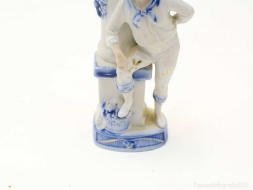 Charming porcelain figurine of a man and child celebrating friendship and joy in blue and white.