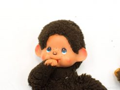 Charming vintage Monchhichi doll with large blue eyes and fuzzy outfit, perfect for collectors.