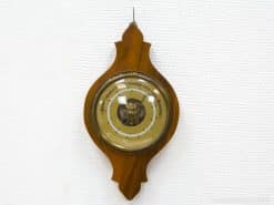 Elegant vintage barometer with wooden frame and glass dome, perfect for stylish weather tracking.