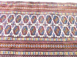 Colorful vintage tablecloth with intricate floral and geometric patterns, adding cultural charm to decor.