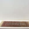 Vintage handmade runner rug with rich red hues and intricate geometric patterns.