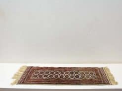 Vintage handmade runner rug with rich red hues and intricate geometric patterns.