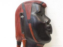 Intricate wooden human face sculpture, symbolizing culture and craftsmanship with rich detail.