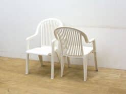 Stylish white plastic chairs ideal for cozy conversations in a minimalist indoor space.