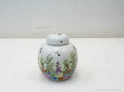 Elegant porcelain jar with vibrant floral and bee designs, perfect for decor and storage.