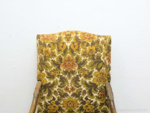 Vintage floral chair with warm colors and wooden details, ideal for cozy retro interiors.