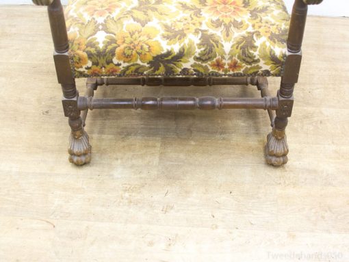 Ornate vintage chair with floral upholstery and lion claw feet, ideal for classic decor.