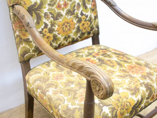 Charming vintage armchair featuring vibrant floral upholstery and exquisite wooden craftsmanship.