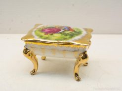 Elegant vintage trinket box featuring a colorful pastoral scene and luxurious gold accents.