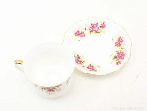 Vintage porcelain tea cup and saucer with pink roses and gold accents, perfect for elegant gatherings.