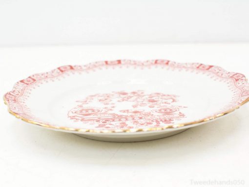 Elegant porcelain plate with red floral designs and gold scalloped rim for sophisticated table decor.