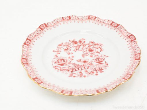 Elegant porcelain plate with red floral pattern and gold trim, perfect for special occasions.