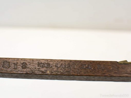 Antique wooden ruler with engravings and metal accents, exemplifying fine craftsmanship and history.