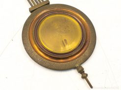 Vintage metal disk with shiny gold center and textured rim, perfect for collectors and decor.