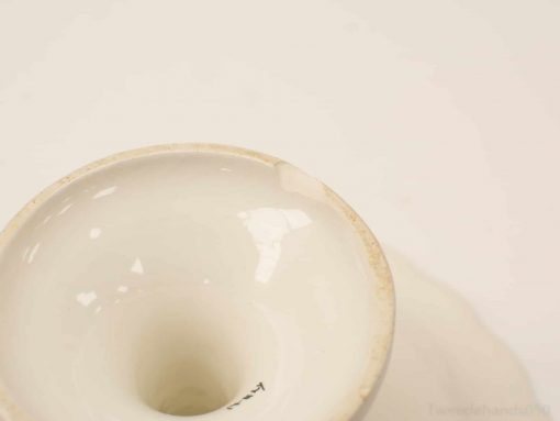 Elegant porcelain bowl with a charming chip, showcasing vintage craftsmanship and rich history.