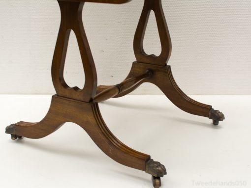 Elegant accent table with intricately carved legs and wheels for easy mobility and style.