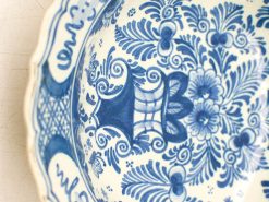 Elegant blue and white ceramic bowl with floral designs and scalloped edge, perfect for decor.