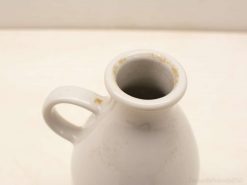 Charming white ceramic jug with elegant design and unique imperfections for decorative and functional use.