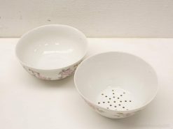 Elegant porcelain mixing bowl and colander with floral design for stylish kitchen use.