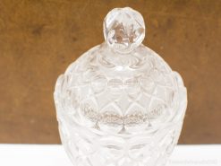 Elegant crystal jar with faceted lid, ideal for stylish decor and functional storage.