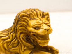 Intricately detailed yellow lion sculpture embodying strength and majesty for art enthusiasts.